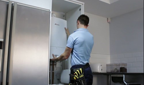 Heating engineer installing boiler