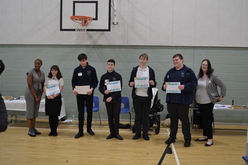 Students holding certificates at a Swale Heating sponsored school community event