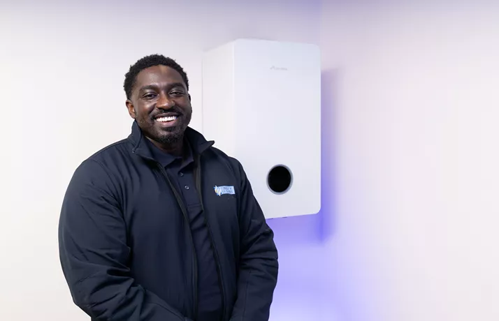 Swale Heating engineer smiling in front of boiler