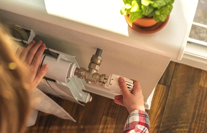 Lady Adjusting Radiator Valve