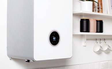 Sleek white energy-efficient gas boiler with a circular display on a kitchen wall