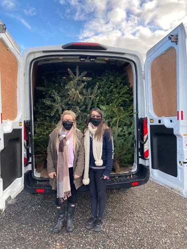 Two Swale Heating staff with a van full of Christmas trees for community delivery