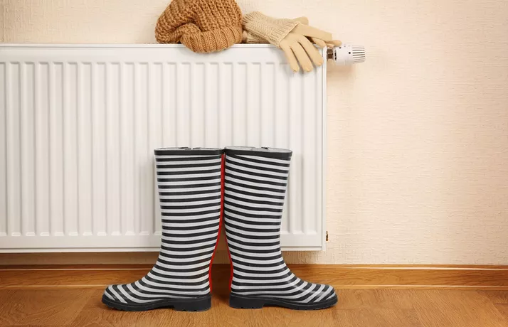 A Pair Of Wellington Boots By A Radiator