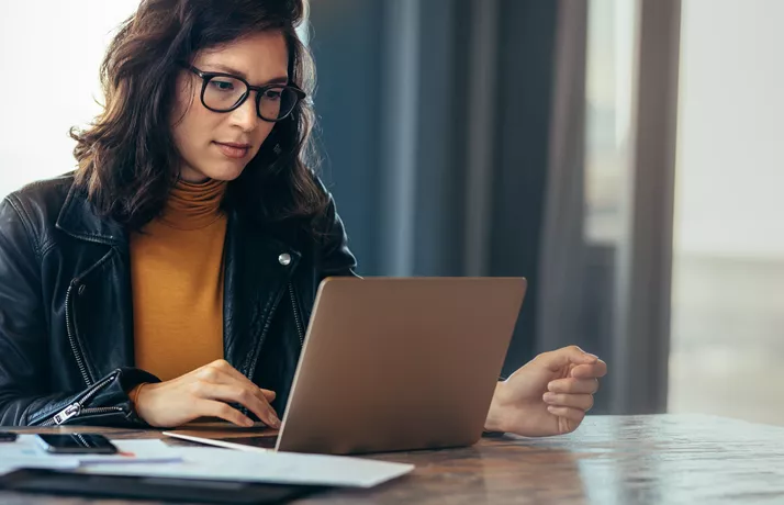 Woman with glasses working on laptop