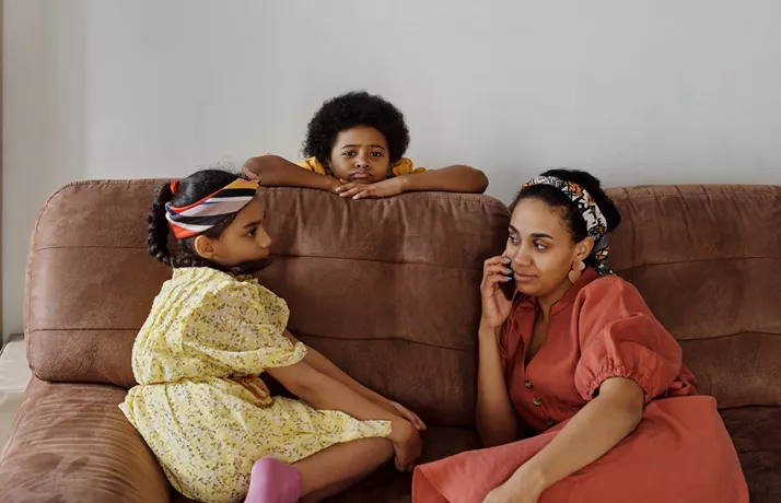 Two children and adult sitting on a sofa