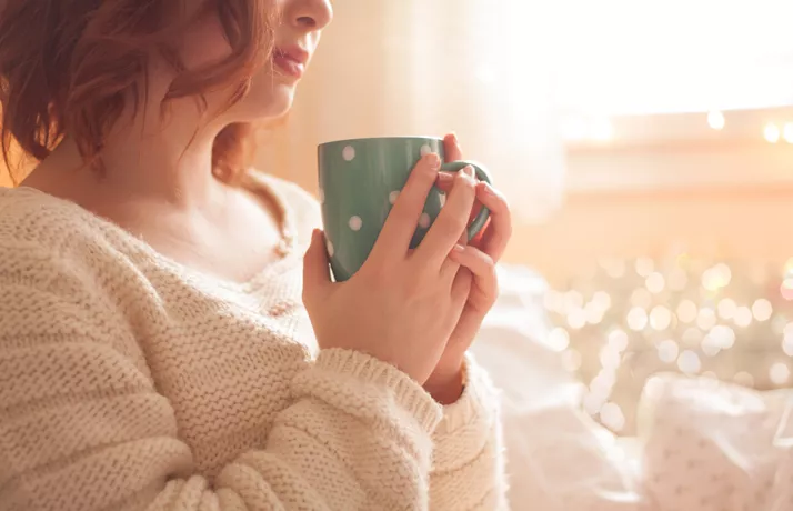 Woman holding a hot drink in a mug