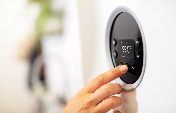 Finger changing temperature on thermostat